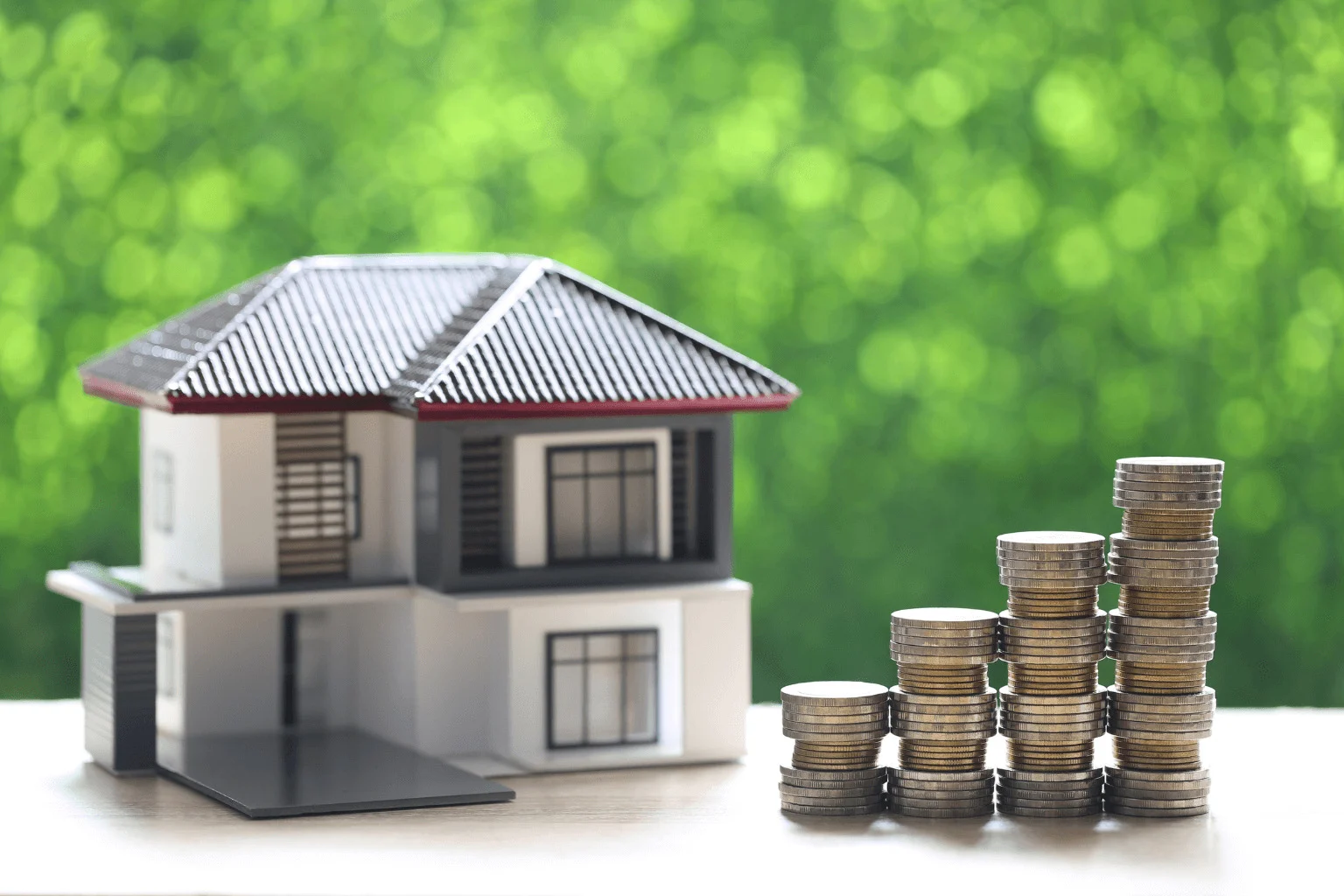 stack of coins and a house model