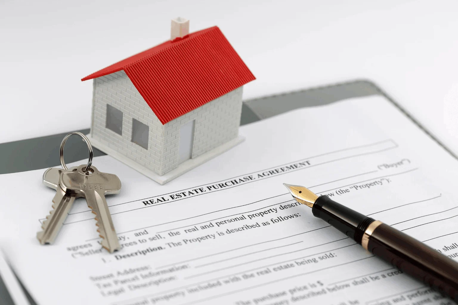real estate paperwork with a pen and key